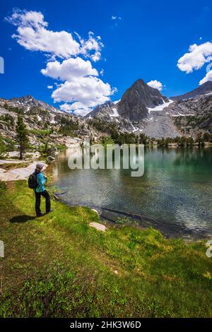 Escursionista sulle rive del lago Treasure, John Muir Wilderness, Sierra Nevada Mountains, California, USA. Foto Stock