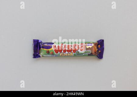 Cadbury Wispa Gold sapore di nocciola in edizione limitata barra di cioccolato su sfondo grigio, spazio copia. Praga, Repubblica Ceca - 2 gennaio 2022 Foto Stock