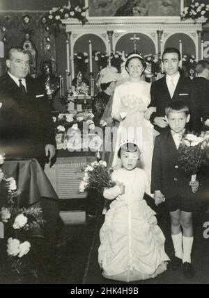 Matrimonio in Italia nel 1950s: Lo sposo attende la sposa nella chiesa con la madre Foto Stock