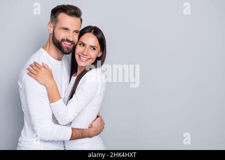 Foto di ragazzo sognante signora vestito camicie bianche cercando spazio vuoto abbracciando isolato grigio sfondo di colore Foto Stock