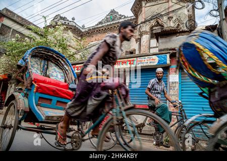 Pulitori di risciò per le strade di Puran Dhaka - Old Dhaka in Bangladesh. I risciò sono tricicli alimentati a pedale, ma usati per essere tirati a mano, da qui 'estrattore di risciò'. Oggi molti dei risciò sono persino convertiti per essere alimentati da un motore elettrico. Foto Stock