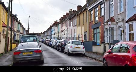 Piccola strada residenziale in città con auto parcheggiate su entrambi i lati della strada stretta, Bristol, Regno Unito Foto Stock