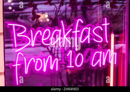 colazione dalle 10:00. la vetrina dei caffè al neon è luminosa Foto Stock