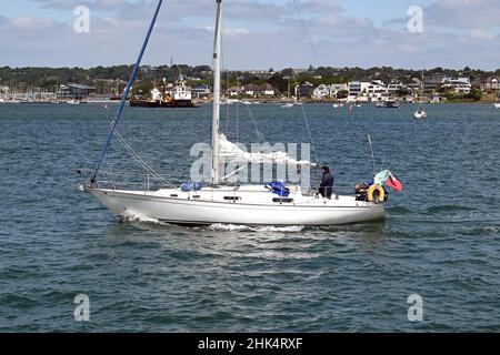 Poole Harbour, Dorset, Inghilterra - Giugno 2021: Persona a vela uno yacht nella grande baia d'acqua vicino Poole Harbour Foto Stock
