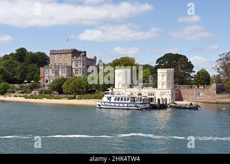 Poole Harbour, Dorset, Inghilterra - Giugno 2021: Piccolo traghetto passeggeri al molo per i visitatori di Brownsea Island, fotografato da una barca di passaggio. Foto Stock