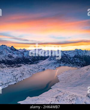 Veduta aerea del lago ghiacciato Lago Bianco al passo di Bernina coperto di neve all'alba, Engadina, Graubunden, Svizzera, Europa Foto Stock