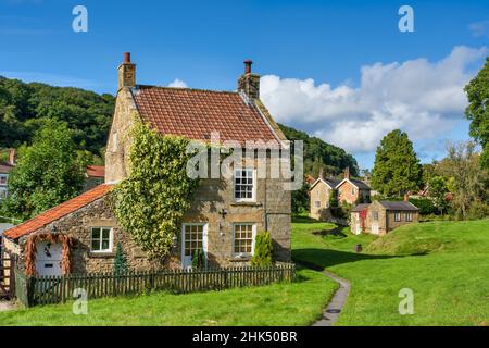 Case in pietra intorno al villaggio verde a Moorland villaggio di Hutton le Hole sul North Yorkshire Moors, Yorkshire, Inghilterra, Regno Unito, Europa Foto Stock