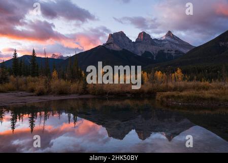 Alba colorata su tre Sorelle al policeman Creek in autunno, Canmore, Banff, Alberta, Canadian Rockies, Canada, Nord America Foto Stock