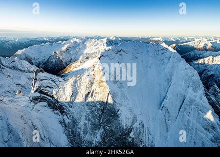 Veduta aerea di maestose rocce del Pizzo Badile innevato in inverno, Val Bregaglia, Cantone di Graubunden, Svizzera, Europa Foto Stock