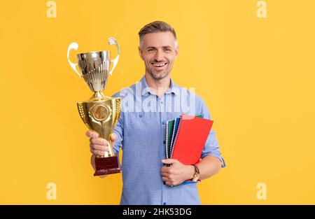 il ragazzo celebra la vittoria, l'ispirazione e la motivazione. l'uomo maturo felice tiene la tazza d'oro Foto Stock