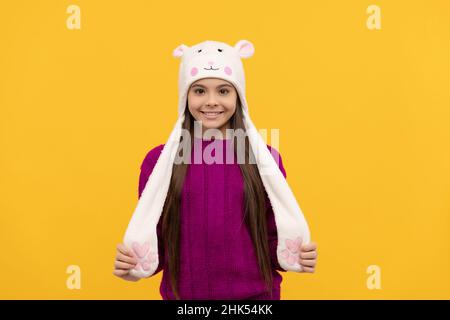 ragazza teen in maglieria. esprimere l'emozione positiva. bambino positivo in cappello con paraspruzzi. Foto Stock