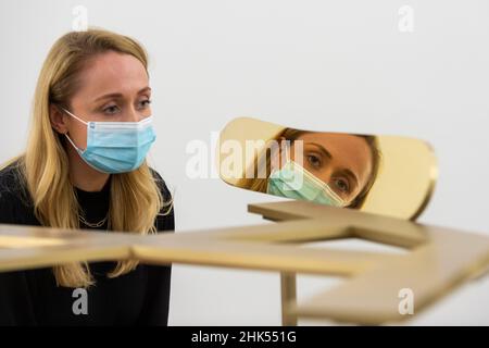 Londra, Regno Unito. 2 febbraio 2022. Un membro dello staff pone con “Paesaggio”, 1987, lastra di bronzo, di Isamu Noguchi. Anteprima di “A New Nature”, una mostra personale di Isamu Noguchi (1904–88), prodotta in collaborazione con la Fondazione Isamu Noguchi e il Garden Museum di New York, in mostra al White Cube Bermondsey dal 4 febbraio al 3 aprile 2022. Credit: Stephen Chung / Alamy Live News Foto Stock