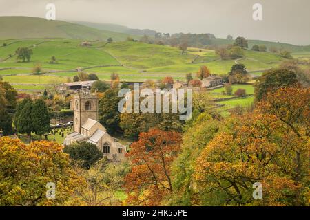 I colori autunnali circondano la chiesa di St. Wilfrid nel villaggio di Yorkshire Dales di Burnsall, Wharfedale, North Yorkshire, Inghilterra, Regno Unito, Europa Foto Stock