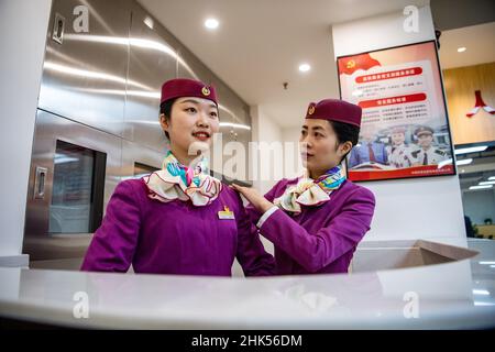 (220202) -- CHONGQING, 2 febbraio 2022 (Xinhua) -- Lin Mengfan (L) partecipa ad una sessione di addestramento prima della partenza alla stazione ferroviaria di Chongqing North a Chongqing, Cina sudoccidentale, 2 febbraio 2022. Nato nel 2000, Lin Mengfan è una nuova superba stazione per un treno superveloce Fuxing sulla ferrovia di Chendu-Chongqing. Nel frattempo, Lin è al servizio della corsa di corsa del festival di primavera per la prima volta nella sua carriera. Nel caso in cui ci sia un passeggero che ha bisogno di aiuto a bordo, Lin ha preparato con lei una custodia versatile per attrezzi. Nella custodia sono gli adesivi colorati per i passgenger di marcare i loro bagagli, cartoni animati adesivi per piacere littl Foto Stock