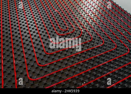 fllor riscaldamento tubi nella casa in costruzione con luce Foto Stock