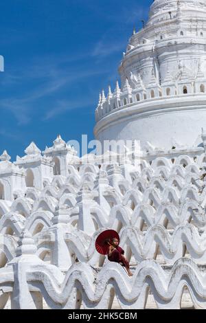 Giovane debuttante monaco buddista holding ombrellone a Pagoda Myatheindan (noto anche come Pagoda Hsinbyume), Mingun, Myanmar (Birmania), l'Asia in febbraio Foto Stock