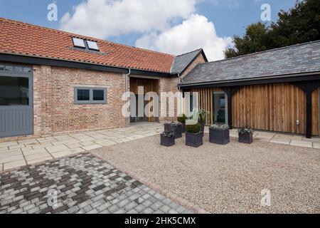 Trumpington, Cambridgeshire - Maggio 04 2017: Facciata esterna e l'elevazione del contemporaneo fienile conversione fornendo nuove case di lusso da ex rosso Foto Stock