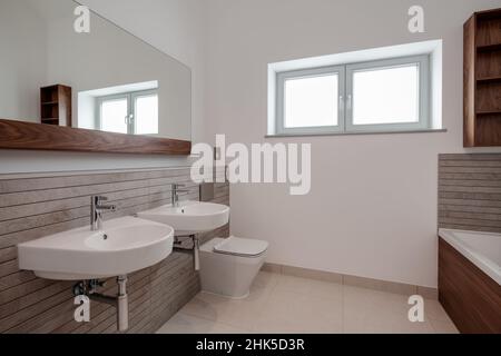 Trumpington, Cambridgeshire - Maggio 04 2017: Camera da bagno minimalista di lusso contemporaneo con doccia all'interno di una nuova casa con pareti piastrellate e dipinte di bianco Foto Stock