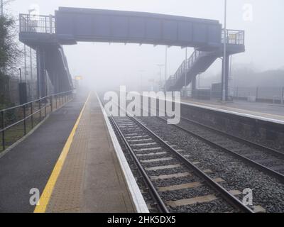 In una giornata di mezzogiorno d'inverno nebbia come questa, anche il mondano può essere trasformato dalla bellezza. La stazione ferroviaria di Radley è avvolta nella nebbia e nel mistero, mentre spec Foto Stock