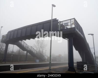 In una giornata di mezzogiorno d'inverno nebbia come questa, anche il mondano può essere trasformato dalla bellezza. La stazione ferroviaria di Radley è avvolta nella nebbia e nel mistero, mentre spec Foto Stock