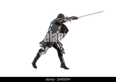 Ritratto di coraggioso guerriero medievale, cavaliere in speciale cappotto di posta attaccando con la spada isolato su bianco studio backgronde Foto Stock