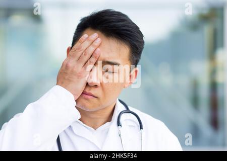 ritratto del medico asiatico uomo stanco dopo lavoro primo piano foto Foto Stock