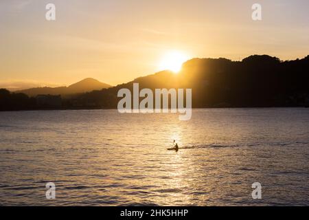 Canoa al tramonto nella baia la Concha di San Sebastian, Spagna Foto Stock