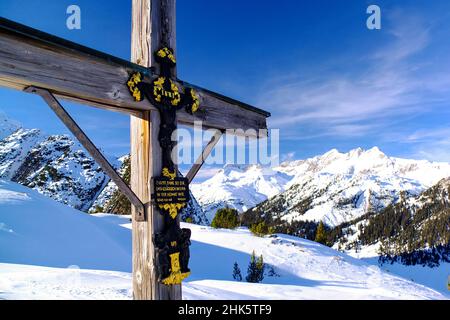 Crocifisso in legno nelle Alpi austriache in inverno. Foto Stock