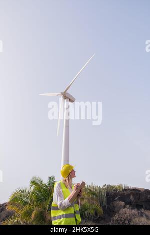 giovane donna che fa la prova con i mulini di energia di vento Foto Stock