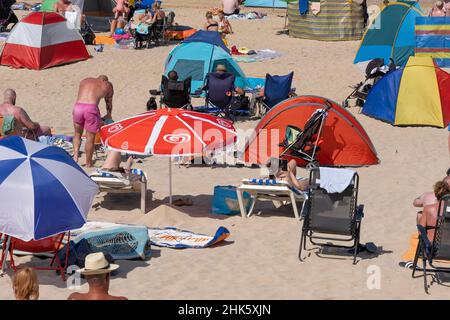 Il caldo intenso e il sole senza sosta attirano la folla di turisti sulla Fistral Beach a Newquay in Cornovaglia. Foto Stock