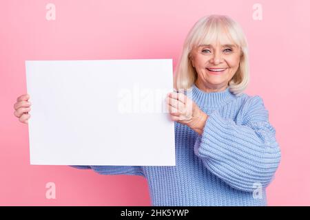 Ritratto di attraente ragazza allegra grigio-pelata che dimostra bianco bordo copia spazio annuncio isolato su sfondo rosa pastello colore Foto Stock