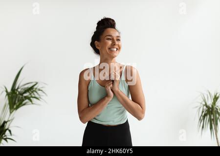 Ritratto di allegro felice giovane bella Donna in Activewear in piedi al chiuso Foto Stock