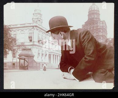 Uomo reclinabile che si affaccia sulla stazione della metropolitana di New York City - la fotografia di Montage mostra l'uomo gigantesco in abito e cappello bowler sovrapposto sulla scena stradale. Foto Stock