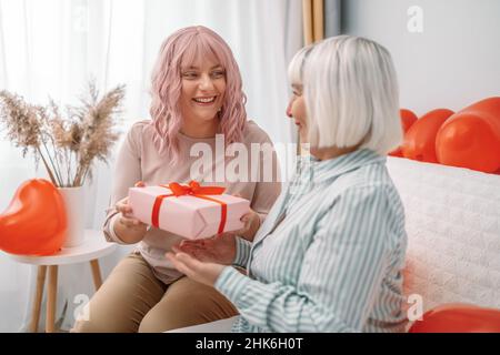 La donna caucasica felice ottiene il regalo dalla figlia. Foto Stock