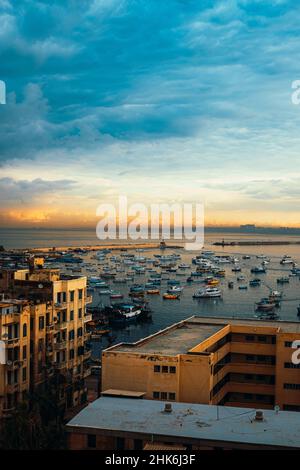 Scatto verticale della baia di alessandria, incredibile ora d'oro all'alba. Vista da un alto edificio di appartamenti della zona circostante, così tante barche da pesca Foto Stock