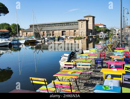 Magazzini salini e barche ormeggiate nel colorato porto del canale di Cervia, Emilia Romagna, Italia Foto Stock