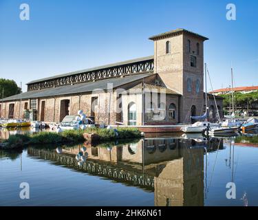Magazzini salini e barche ormeggiate nel colorato porto del canale di Cervia, Emilia Romagna, Italia Foto Stock