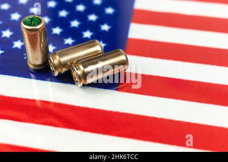 Proiettili della pistola sopra la bandiera americana. Concetto di criminalità e criminalità, corruzione e punizione. USA fuorilegge, ghetto, problema sociale e attacco armato backgro Foto Stock