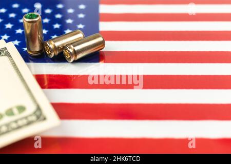 Proiettili di pistola e denaro sopra la bandiera americana. Criminalità e corruzione stati uniti d'america concetto. USA fuorilegge, ghetto, problema sociale e armato a Foto Stock