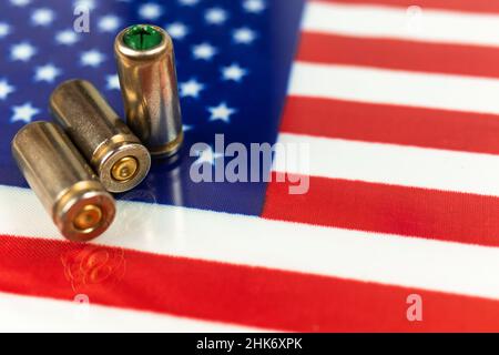 Proiettili della pistola sopra la bandiera americana. Concetto di criminalità e criminalità, corruzione e punizione. USA fuorilegge, ghetto, problema sociale e attacco armato backgro Foto Stock