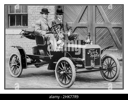 Ford Detroit 1906: David Grey ed Henry Ford fondatore della Ford Motor Company e visionario, seduto nella pista 1905 Ford Model N all'ingresso posteriore dello stabilimento di produzione Ford su Piquette Avenue. Detroit 1906 Ford Model N Runabout due posti in pista come questa Ford Model N 1906 erano favoriti dagli Americani della classe media che potevano permetterne uno. Erano veloci e robusti. La maggior parte dei runabouts ha caratterizzato i motori uno- o due-cilindri e le trasmissioni della catena di bicicletta-stile. Ma questa Ford Model N offriva quattro cilindri e un azionamento dell'albero, più costò meno. A $500, è diventato l'automobile vendente migliore in America. Foto Stock