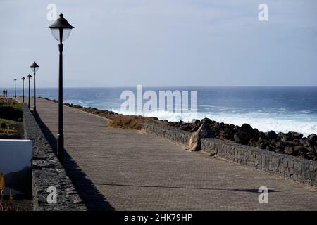 paseo maritimo o passeggiata lungo la costa al mattino presto a punta Pechiguera playa blanca Lanzarote Isole Canarie Spagna Foto Stock