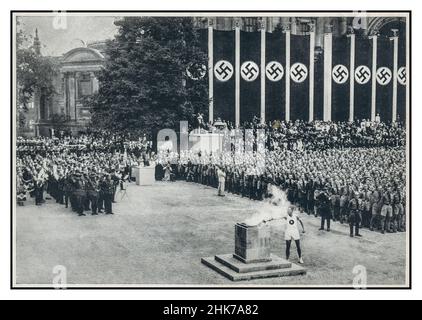 1936 Olimpiadi Berlino nazista Germania. I soldati nazisti salutano per salutare l'arrivo della torcia olimpica e l'inizio dei giochi del 1936. Le bandiere naziste di Swastika dietro per massimizzare il valore della propaganda ad Adolf Hitler e alla Germania nazista Foto Stock