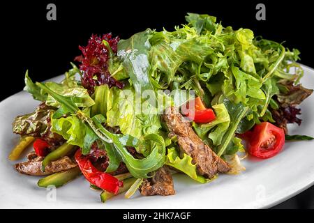 Insalata di vitello, erbe e pomodori su un piatto Foto Stock