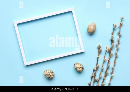 Composizione di Pasqua con cornice fotografica bianca su sfondo blu Foto Stock