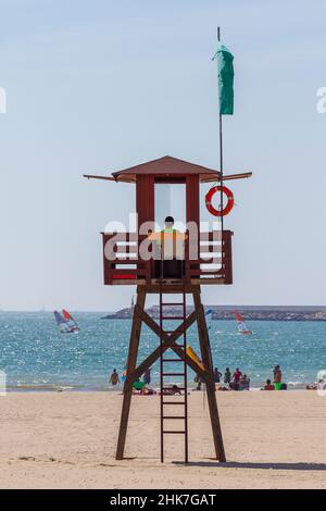 SPIAGGIA DI VALDELAGRANA, CADICE, SPAGNA - 3 SETTEMBRE 2017: Bagnino veglia sulla spiaggia dalla sua torre di guardia per proteggere i bagnanti mentre si godono il bagno di sole Foto Stock