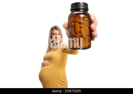 Donna incinta che tiene una bottiglia di pillole di fronte alla macchina fotografica isolato su sfondo bianco Foto Stock