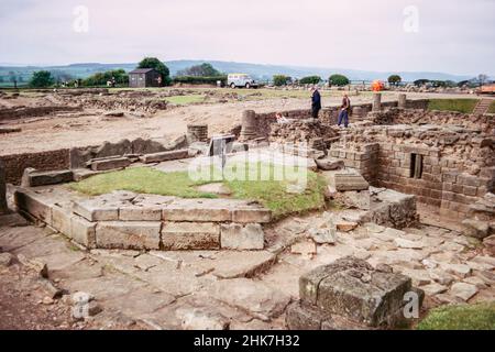 Corbridge vicino a Hexham, Northumberland, Inghilterra - rovine di un grande forte romano Coria, una guarnigione che custodisce il Muro di Adriano. Granai e una fontana. Scansione di archivio da un vetrino. Giugno 1974. Foto Stock