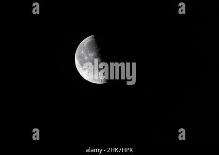 Primo piano della luna che si adora - mezza luna - mattina presto contro il cielo nero. Stoccarda, Germania 25 gennaio 2022 Foto Stock