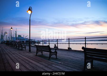 Un tramonto colorato sul fiume Stour dallo storico molo di Ha'Penny, Harwich, North Essex. Trinity House Vessel THV Patricia, ormeggiato nel porto Foto Stock